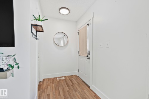 Entryway featuring wood-finish flooring, white trim, and a flush-mount ceiling light - 53 2503 24 Street, Edmonton, AB - Indoor Photo Showing Other Room