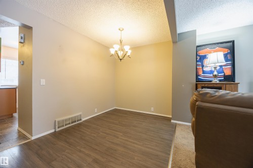 The property features wood-style flooring and light neutral-toned walls, complimented by a ceiling-mounted light fixture - Sherwood Park, AB - Indoor Photo Showing Other Room