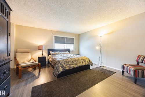 This room features light-toned walls, a window with a roller blind, and durable flooring - Sherwood Park, AB - Indoor Photo Showing Bedroom