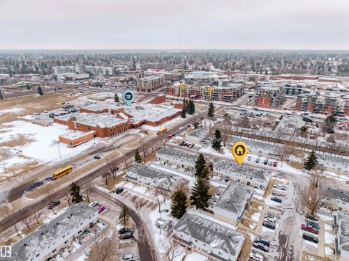 Aerial view showcasing the property's location within a developed neighborhood, featuring residential buildings, streets, and an institutional building with a large parking area - Sherwood Park, AB - Outdoor With View