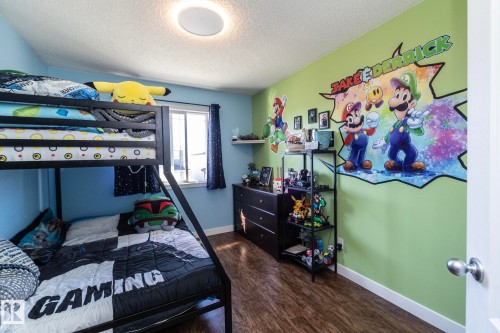 Bedroom featuring a metal bunk bed and wood-finish flooring - 65 Birchmont Drive, Leduc, AB - Indoor Photo Showing Bedroom