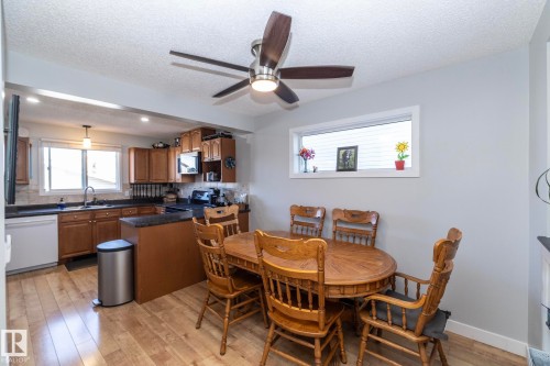 Kitchen and dining area featuring wood-finish flooring - 65 Birchmont Drive, Leduc, AB - Indoor