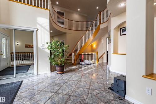 Grand foyer featuring a curved staircase with wood treads and white balusters - 195 Kulawy Drive, Edmonton, AB - Indoor Photo Showing Other Room