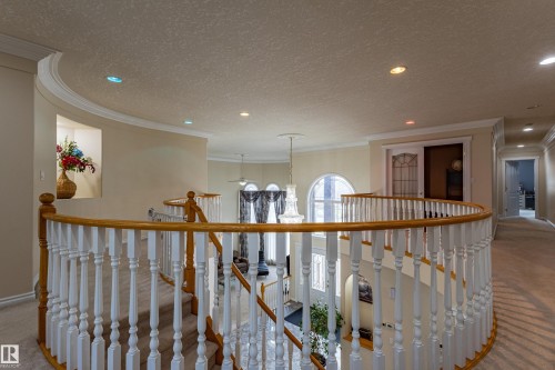 Curved staircase featuring white balusters and a wood-finish handrail - 195 Kulawy Drive, Edmonton, AB - Indoor Photo Showing Other Room