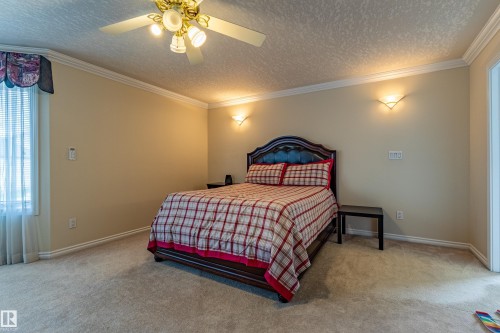 Carpeted room featuring crown molding, neutral wall color, and a ceiling fan with integrated lighting - 195 Kulawy Drive, Edmonton, AB - Indoor Photo Showing Bedroom
