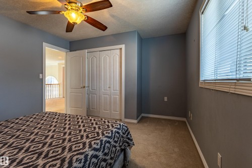 Bedroom featuring a ceiling fan with integrated lighting, carpet flooring, and a window with horizontal blinds - 195 Kulawy Drive, Edmonton, AB - Indoor Photo Showing Bedroom