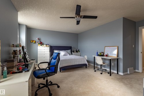 Spacious room featuring neutral carpeting, light blue walls, and a textured ceiling - 195 Kulawy Drive, Edmonton, AB - Indoor Photo Showing Other Room