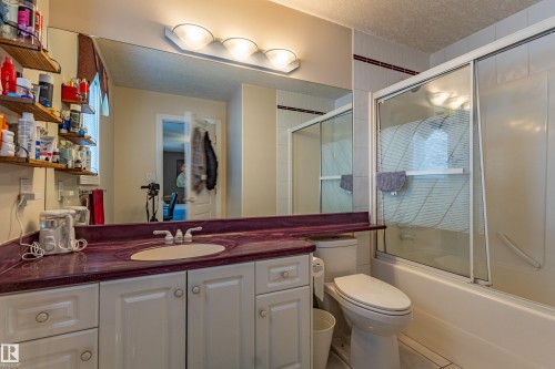 Bathroom vanity featuring a built-in sink, expansive mirror, and a purple-hued countertop - 195 Kulawy Drive, Edmonton, AB - Indoor Photo Showing Bathroom