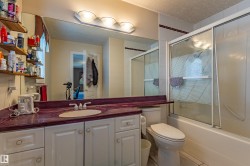 Bathroom vanity featuring a built-in sink, expansive mirror, and a purple-hued countertop - 