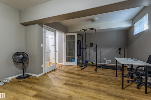 Finished room featuring wood-finish flooring, recessed lighting, and a window with blinds - 195 Kulawy Drive, Edmonton, AB - Indoor Photo Showing Other Room