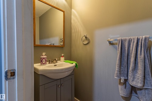 Bathroom vanity featuring a white basin sink, chrome faucet, and gray cabinet storage - 195 Kulawy Drive, Edmonton, AB - Indoor Photo Showing Bathroom