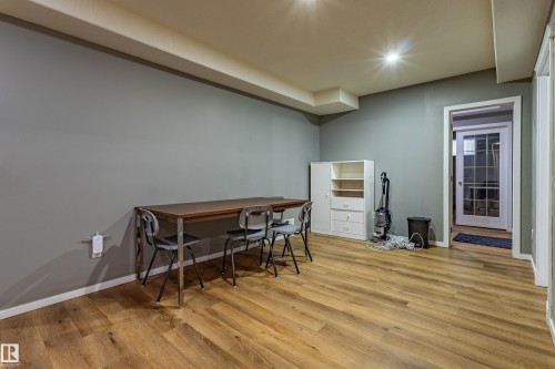 Spacious room featuring wood-finish flooring, recessed lighting, and a neutral wall color palette - 195 Kulawy Drive, Edmonton, AB - Indoor