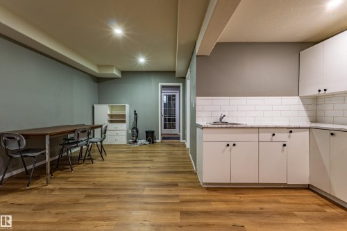 Laminate wood-finish flooring extending through an open-concept room - 195 Kulawy Drive, Edmonton, AB - Indoor