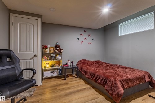 Room featuring wood-finish flooring, recessed ceiling lighting, and a white interior door with a paneled design - 195 Kulawy Drive, Edmonton, AB - Indoor Photo Showing Bedroom