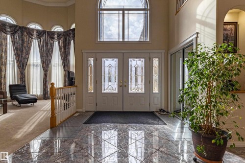 Grand entryway featuring double doors with decorative glass panels and a transom window above - 195 Kulawy Drive, Edmonton, AB - Indoor Photo Showing Other Room