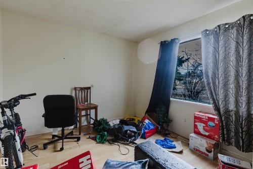 Light-toned wall finishes complement the wood-finish flooring in this room, featuring a single window opening - 12223 127 Street, Edmonton, AB - Indoor