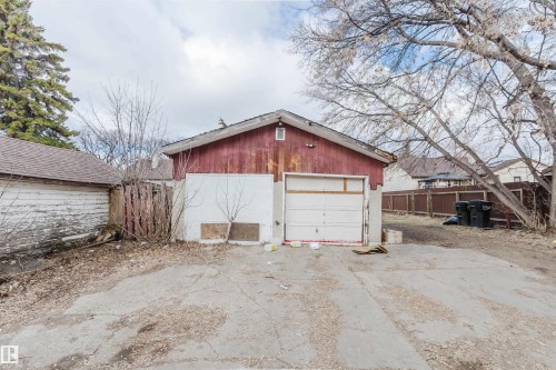 Detached garage with a single overhead door, an asphalt driveway, and a partially fenced perimeter - 12223 127 Street, Edmonton, AB - Outdoor