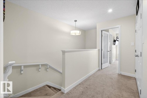 Upper-level hallway featuring neutral wall tones, textured ceiling, and carpeted flooring - 5315 22 Avenue, Edmonton, AB - Indoor Photo Showing Other Room