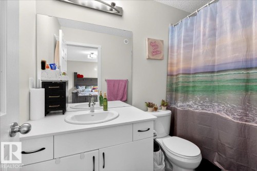 Bathroom featuring a white vanity with an undermount sink, a chrome faucet, and a large wall-mounted mirror - 5315 22 Avenue, Edmonton, AB - Indoor Photo Showing Bathroom