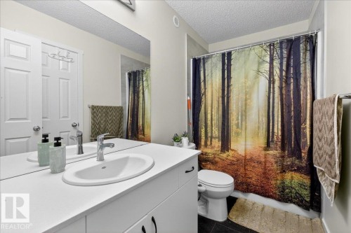 Vanity area featuring a single basin sink set into a white countertop, with a large wall-mounted mirror - 5315 22 Avenue, Edmonton, AB - Indoor Photo Showing Bathroom