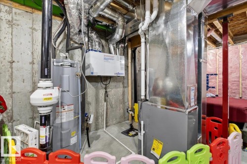 Utility area featuring a water heater, furnace, air ducts, and concrete walls - 5315 22 Avenue, Edmonton, AB - Indoor Photo Showing Basement