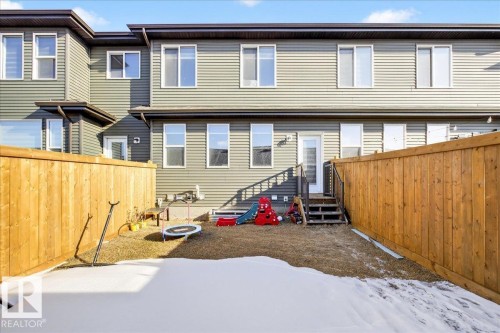 Fully-fenced backyard featuring a wood privacy fence, multi-level exterior and modern horizontal siding - 5315 22 Avenue, Edmonton, AB - Outdoor