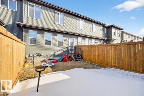Private backyard space featuring a wooden privacy fence, a ground-level deck with steps, and a rear door entry - 5315 22 Avenue, Edmonton, AB - Outdoor