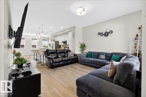 Open-concept living area featuring wood-finish flooring, recessed lighting, and a neutral color palette - 5315 22 Avenue, Edmonton, AB - Indoor Photo Showing Living Room