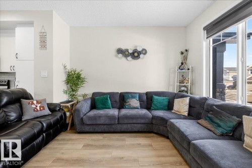 Bright living area featuring wood-finish flooring and expansive windows - 5315 22 Avenue, Edmonton, AB - Indoor Photo Showing Living Room