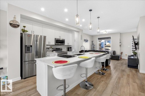 Modern kitchen featuring white cabinetry, stainless steel appliances, a center island with bar seating, and recessed lighting - 5315 22 Avenue, Edmonton, AB - Indoor Photo Showing Kitchen With Upgraded Kitchen