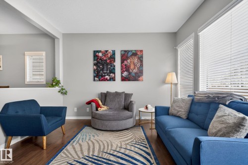 Living area with dark wood-finish flooring, light grey walls, and white trim - 6912 22 Avenue, Edmonton, AB - Indoor Photo Showing Living Room