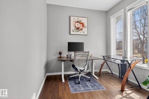 Dedicated office space featuring two large windows, wood-finish flooring, and light gray wall paint - 6912 22 Avenue, Edmonton, AB - Indoor Photo Showing Office