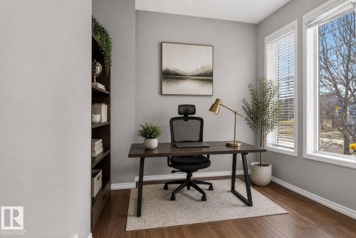 Bright room featuring rich wood-finish flooring and a built-in dark wood bookcase - 6912 22 Avenue, Edmonton, AB - Indoor Photo Showing Office