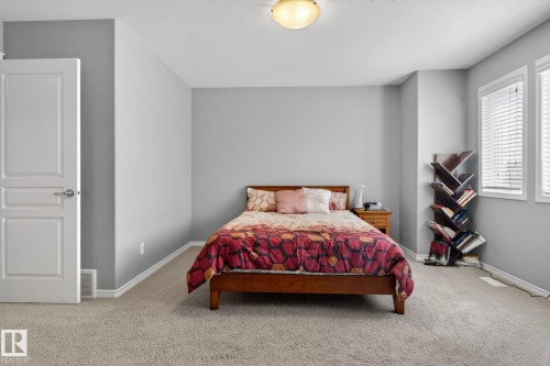 Expansive room featuring light gray wall paint, textured carpet flooring, and white baseboards - 6912 22 Avenue, Edmonton, AB - Indoor Photo Showing Bedroom