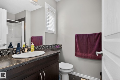Dark wood-finish vanity with an integrated sink and mosaic tile backsplash - 6912 22 Avenue, Edmonton, AB - Indoor Photo Showing Bathroom