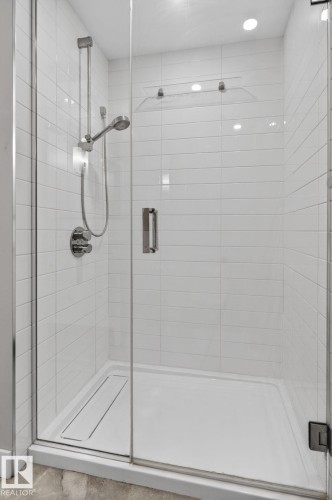 Glass-enclosed shower featuring white subway tile surround, recessed lighting, and a linear drain - 6912 22 Avenue, Edmonton, AB - Indoor Photo Showing Bathroom