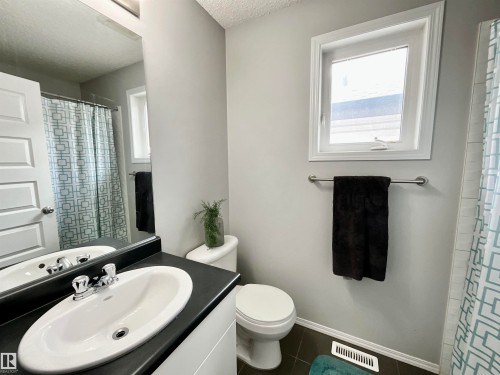 Bathroom featuring a vanity with an integrated sink, a large mirror, and a window for natural light - 17936 85 Street, Edmonton, AB - Indoor Photo Showing Bathroom