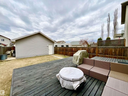 Spacious backyard featuring a dark-stained wooden deck, a detached garage with siding, and a privacy fence - 17936 85 Street, Edmonton, AB - Outdoor With Deck Patio Veranda With Exterior