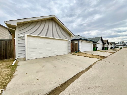 Attached two-car garage with light gray siding and white paneled garage door - 17936 85 Street, Edmonton, AB - Outdoor