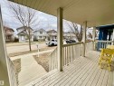 Front porch featuring a wood-finish deck, white railing, and support columns - 17936 85 Street, Edmonton, AB  - Outdoor With Deck Patio Veranda 