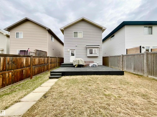 Rear exterior featuring light gray siding, a dark-stained wood deck with steps, and a bay window - 17936 85 Street, Edmonton, AB - Outdoor With Deck Patio Veranda With Exterior