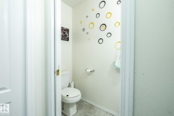 Compact water closet featuring a two-piece toilet, light-toned wall paint, and textured ceiling - 