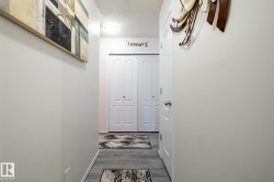 Hallway featuring wood-finish flooring, light-toned walls, and a flush mount ceiling light - 