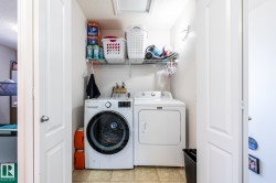 Compact laundry area featuring a front-load washing machine and a top-load dryer - 