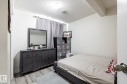 Room featuring wood-finish flooring, white walls, and a ceiling-mounted light fixture - 