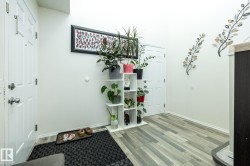 Entryway with light wood-finish flooring, white paneled doors, and high ceilings - 