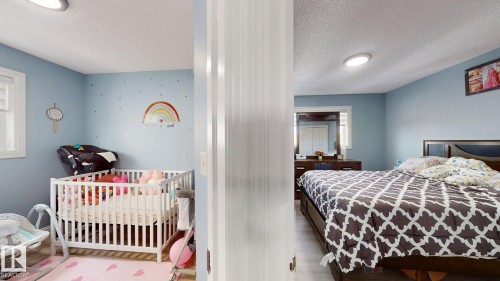 The property features rooms with light blue walls and windows providing natural light - 3613 11 Street, Edmonton, AB - Indoor Photo Showing Bedroom