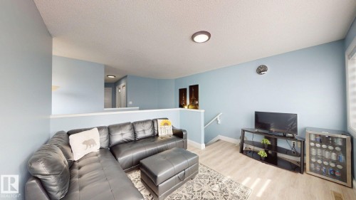 Living area featuring light blue walls, a white ceiling, and light-toned flooring - 3613 11 Street, Edmonton, AB - Indoor Photo Showing Living Room