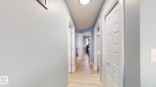 Hallway featuring light blue walls, white trim, and light-colored flooring - 3613 11 Street, Edmonton, AB - Indoor Photo Showing Other Room