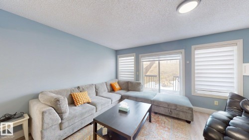 The living area features light blue walls, a textured ceiling, and light-colored flooring - 3613 11 Street, Edmonton, AB - Indoor Photo Showing Living Room